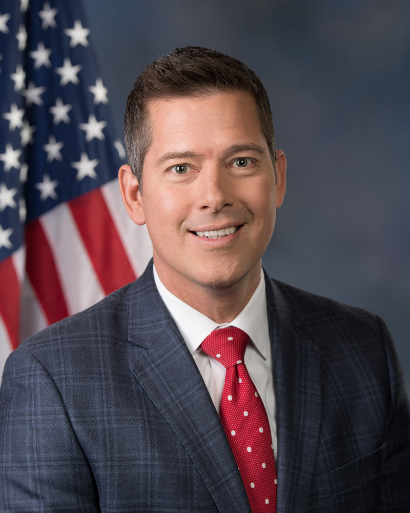 Portrait of man in front of U.S. flag