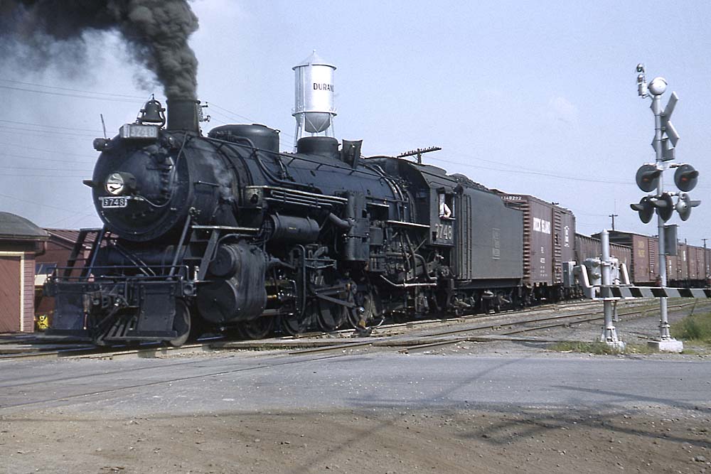 Smoking Grand Trunk Western steam locomotive in road crossing