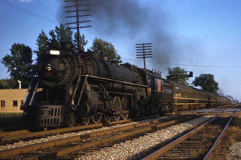 Smoking Grand Trunk Western steam locomotive with passenger train at speed 