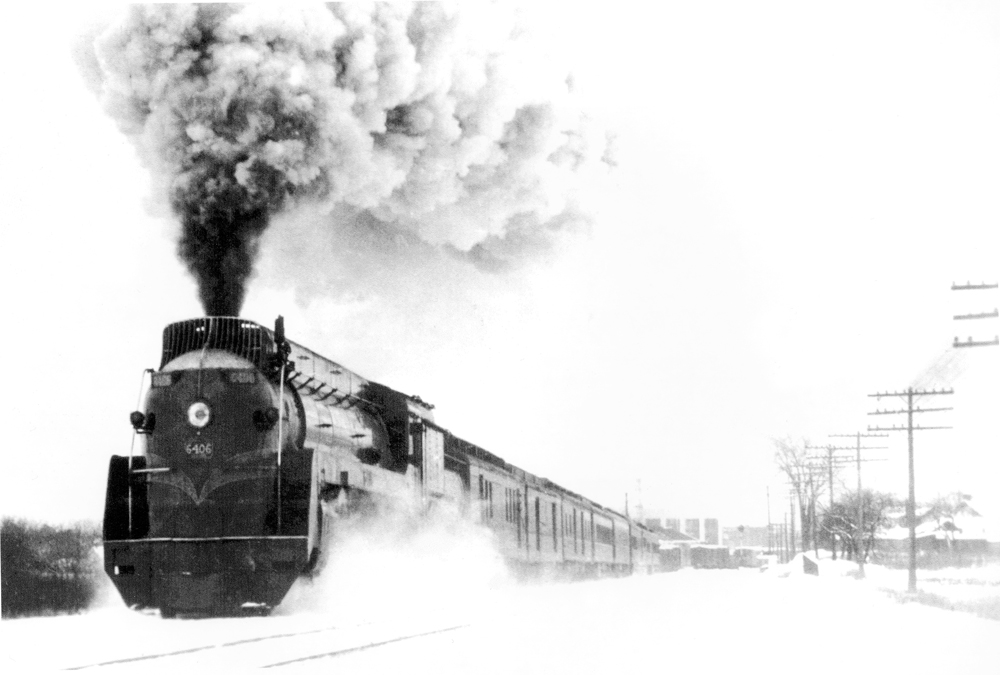 Streamlined steam locomotive with passenger train in snow