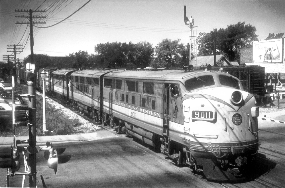 Streamlined diesel locomotives with train crossing street
