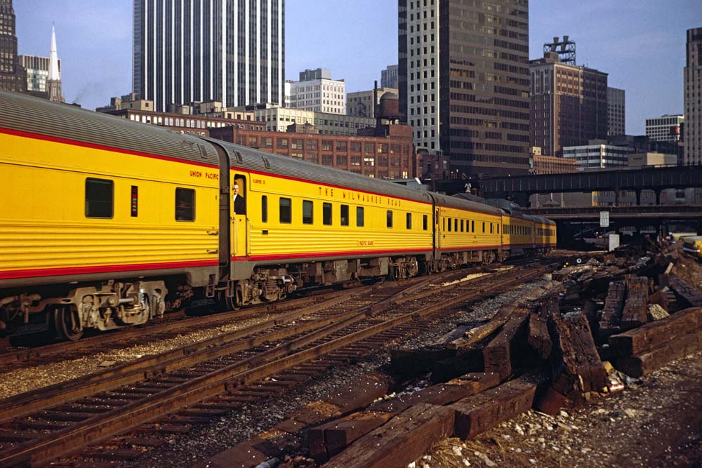 Yellow-and-red Budd streamliners in urban canyon