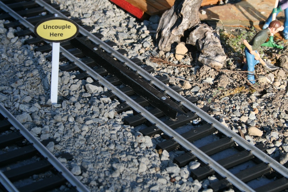 section of track on garden railway with small sign