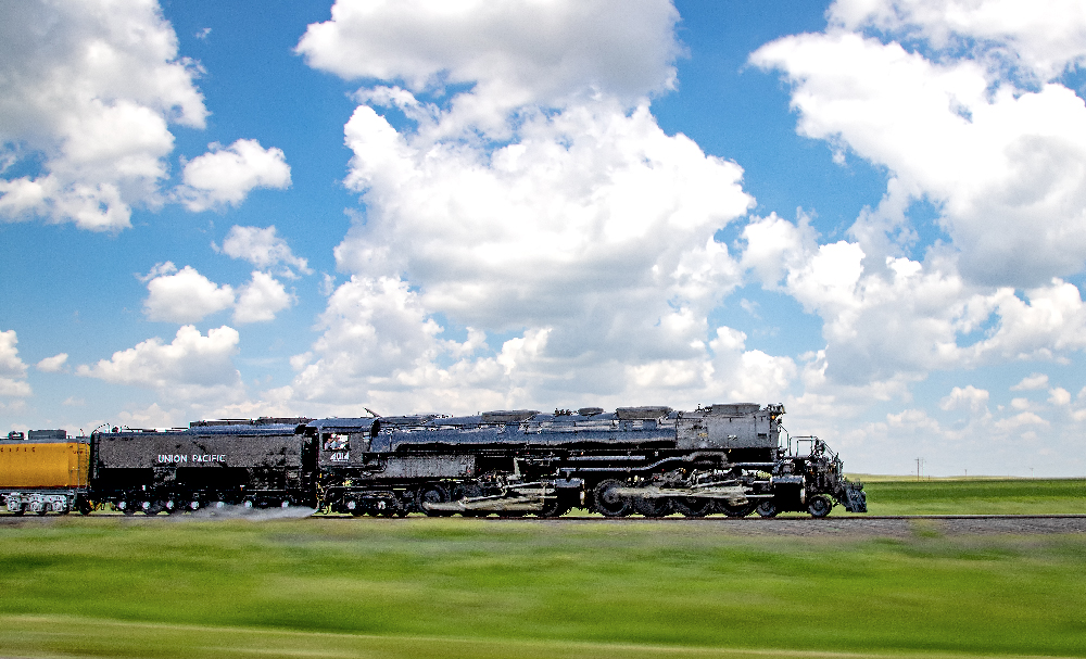 Big Boy steam locomotive paced along highway. Union Pacific Big Boy Home Run Express.