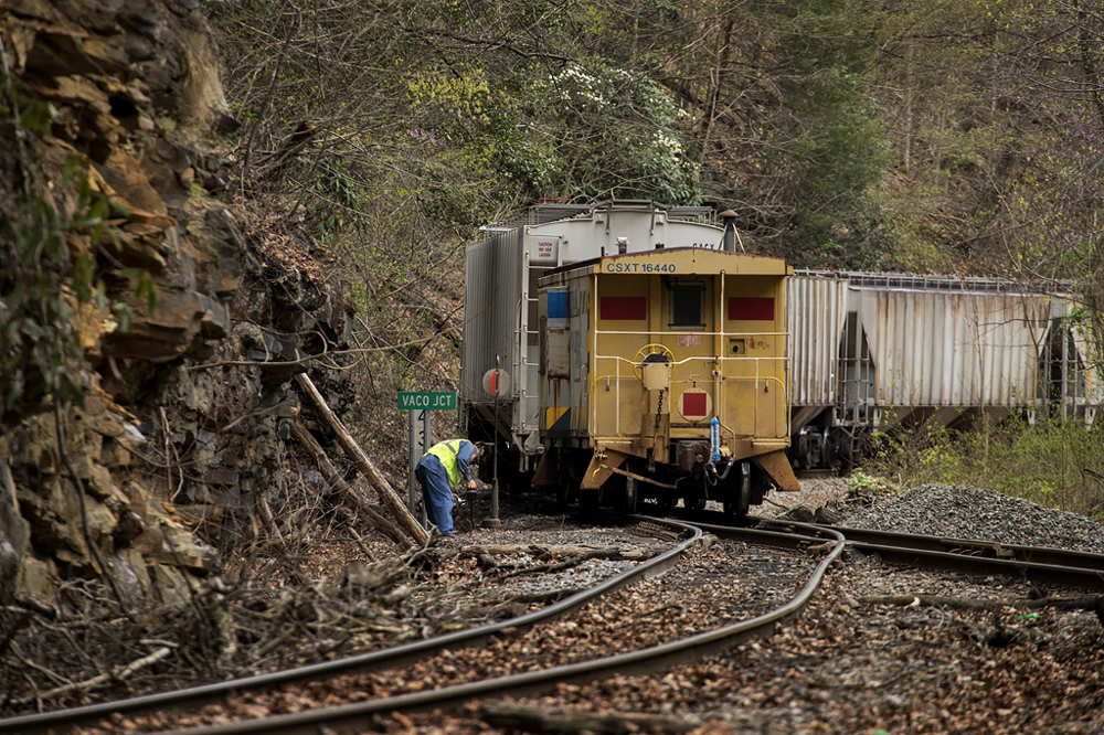 Train crew member throwing switch before reboarding caboose