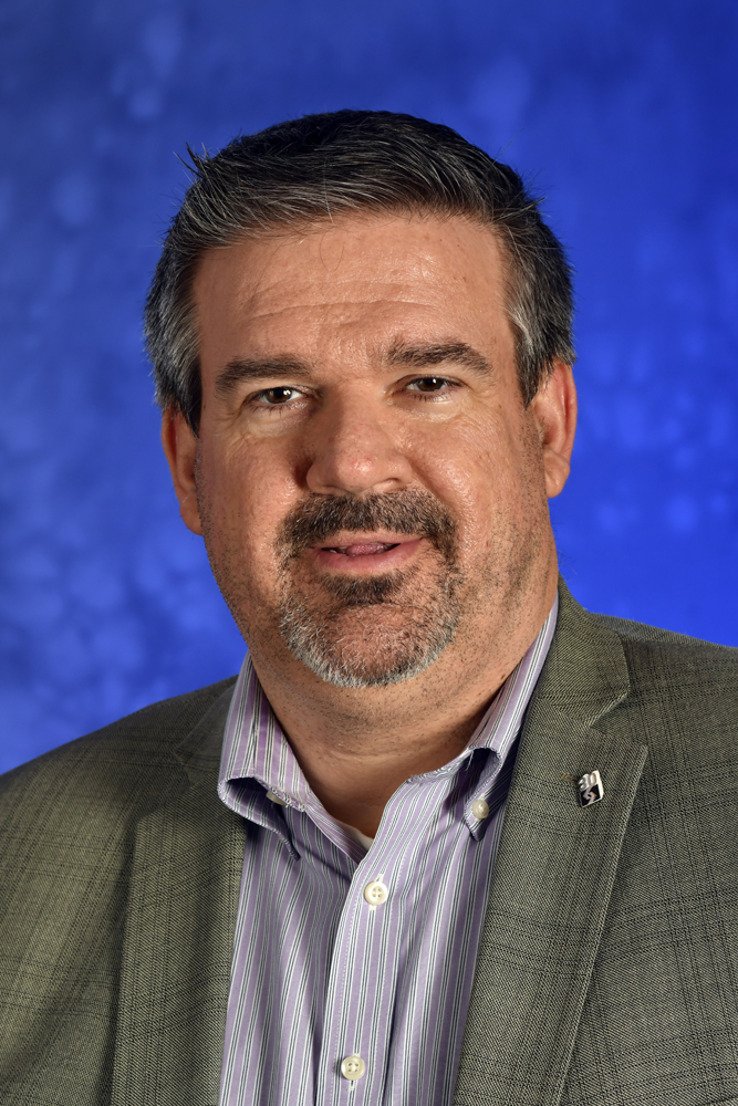 Head shot of man in coat and open-collar shirt
