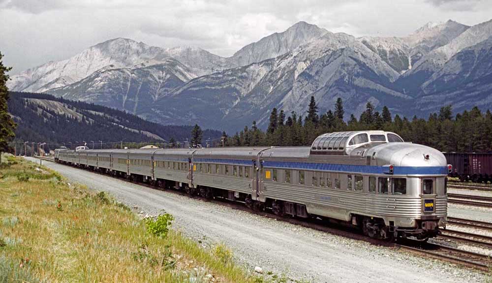 A streamlined passenger train in a mountainous setting