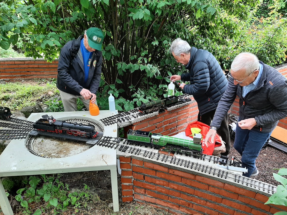 three men servicing model locomotives