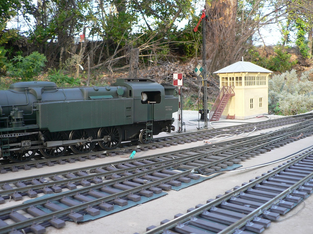 steam locomotive next to small yellow structure