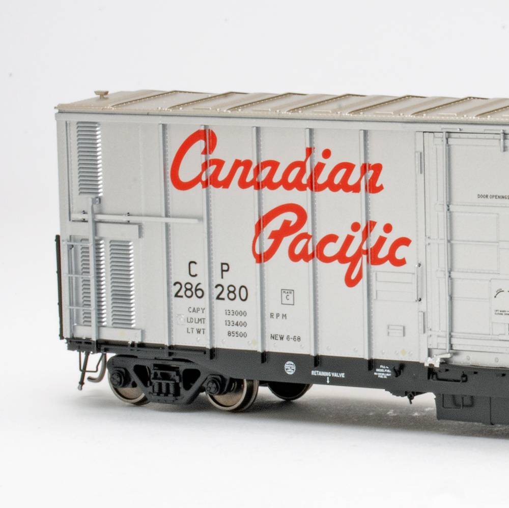 Color photo of HO scale freight car painted silver and black on white background.