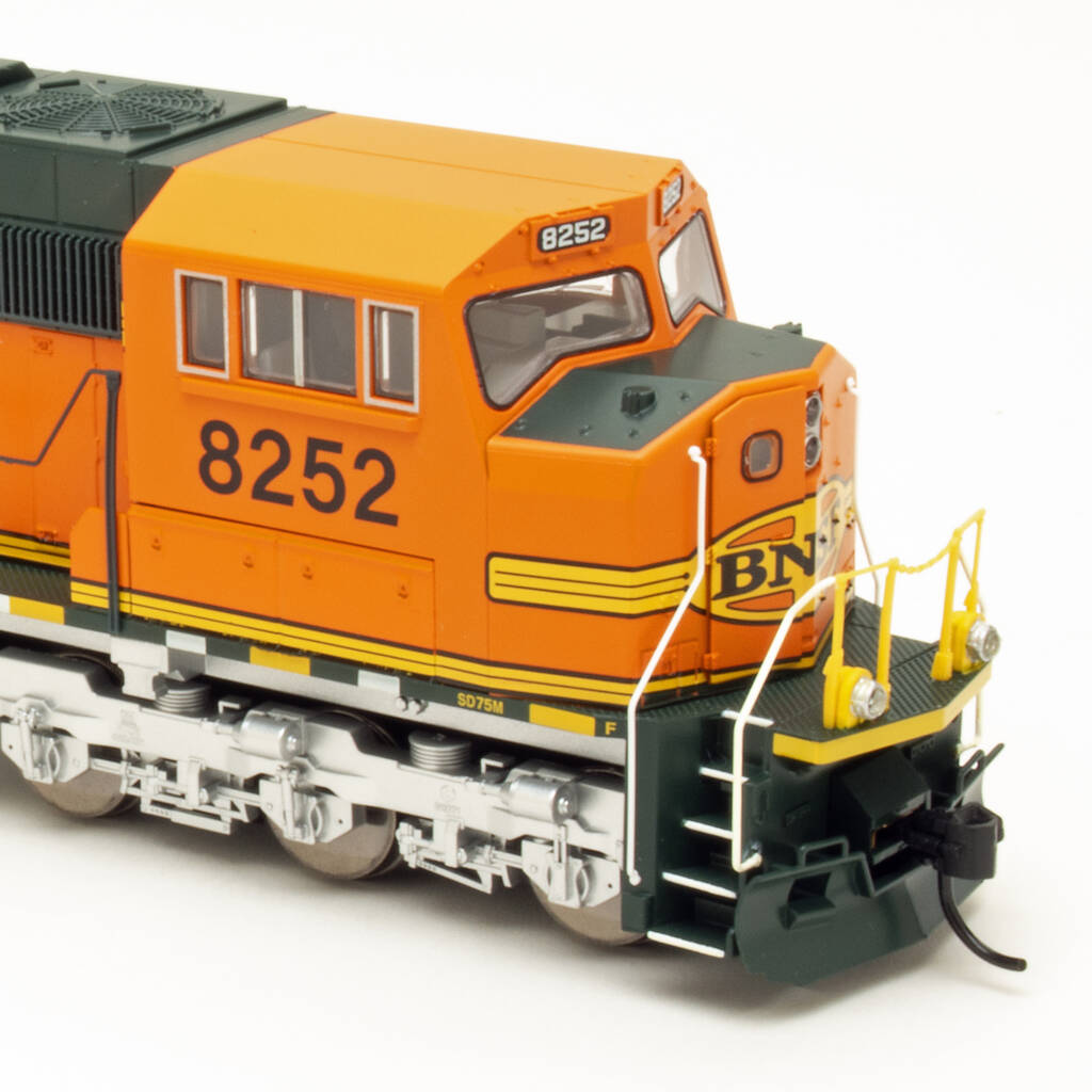 Color photo showing cab of HO scale diesel painted orange, green, and yellow.
