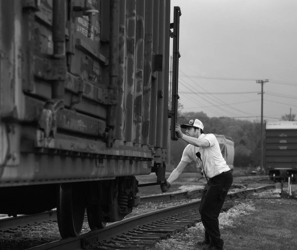 Young individual working on a freight car.
