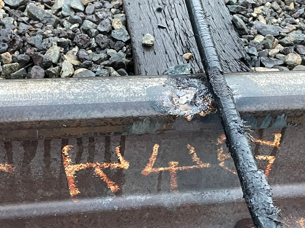 Damaged rail next to electric line across track