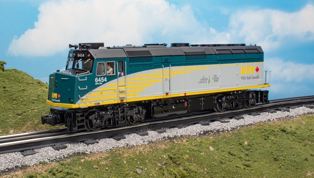 silver, yellow, and green model locomotive on track