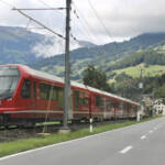 Red train next to highway