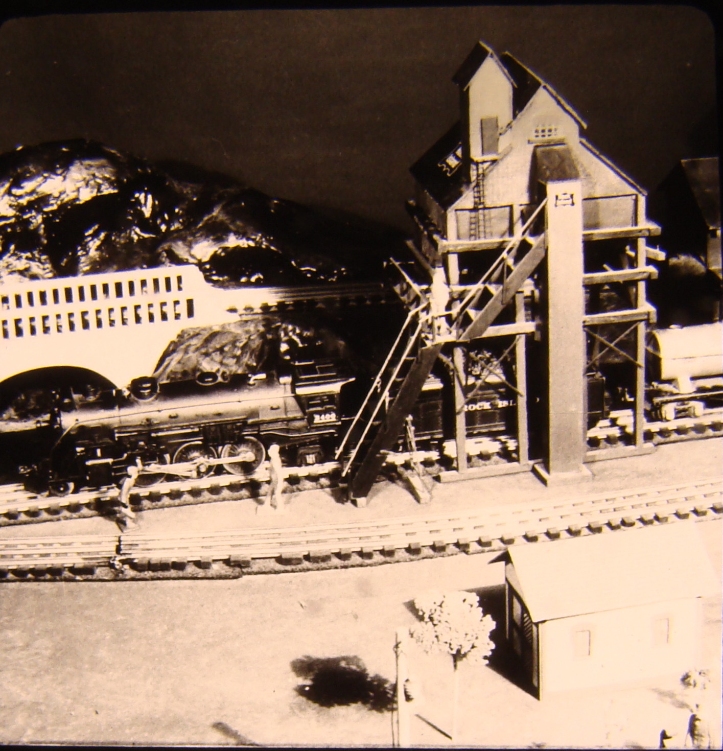 Black and white image on toy train layout with coal tower

