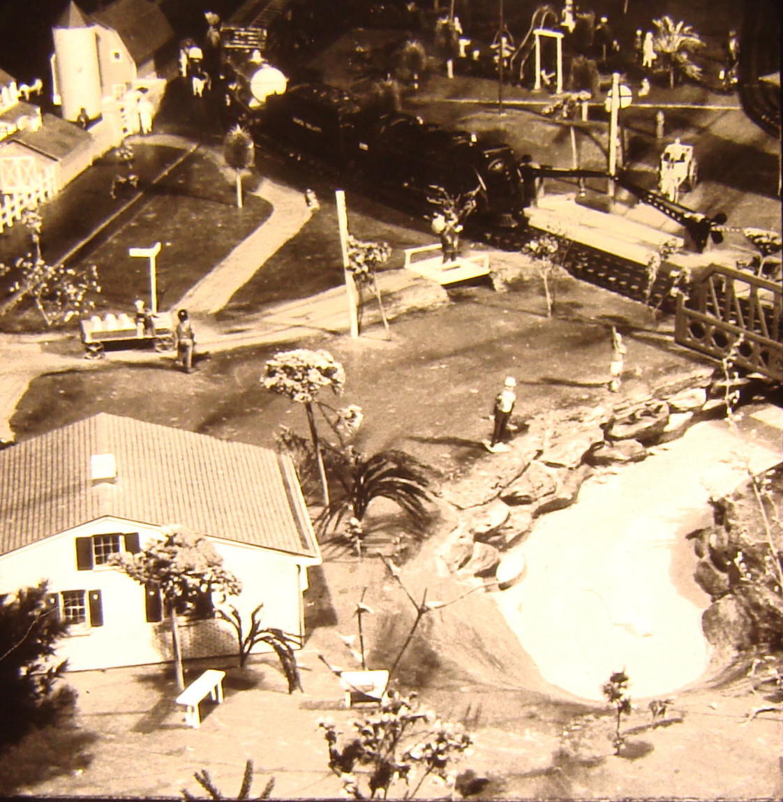 Black and white image on toy train layout with a lake
