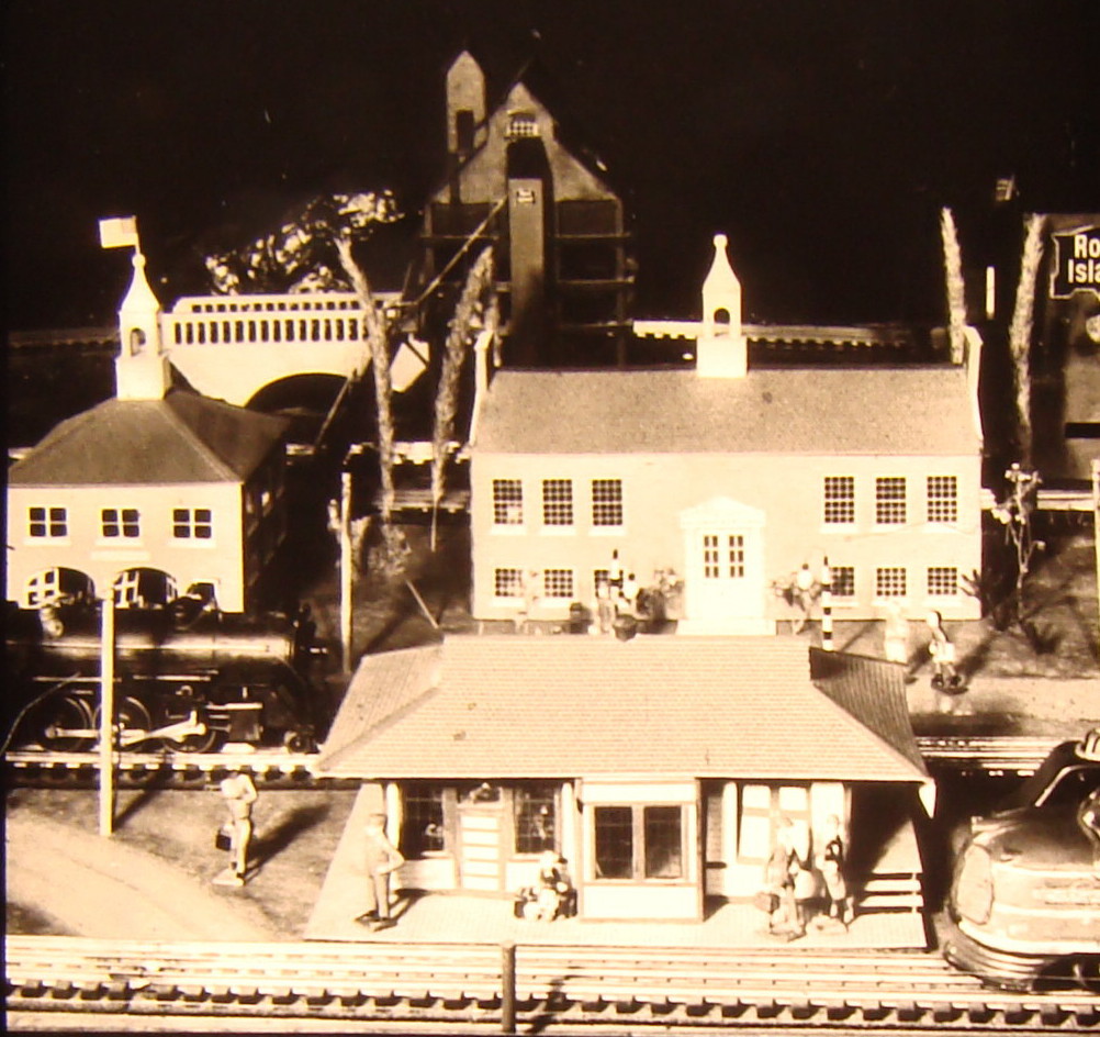 Black and white image of toy train layout with station