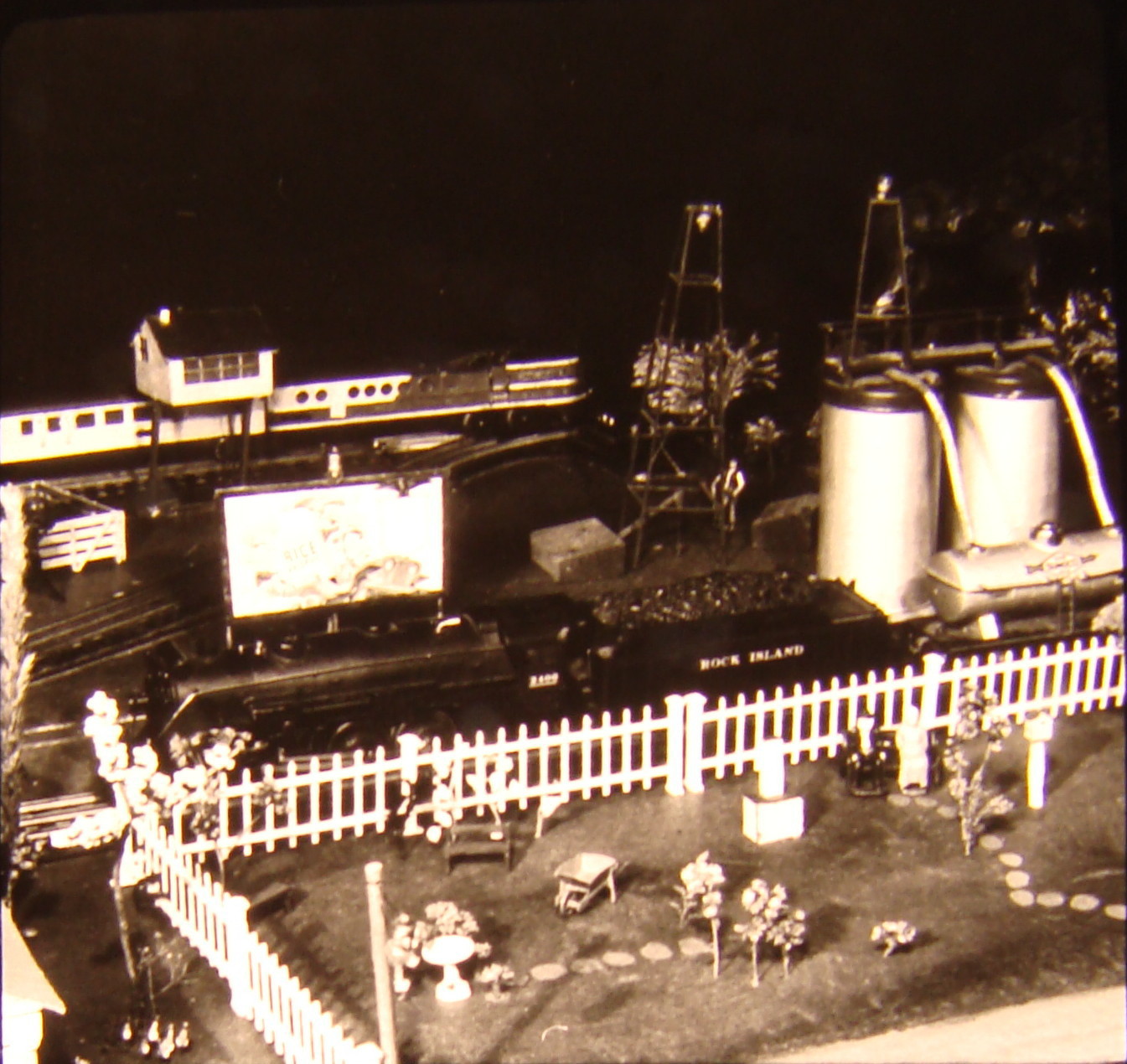 Black and white image on toy train layout with tank car