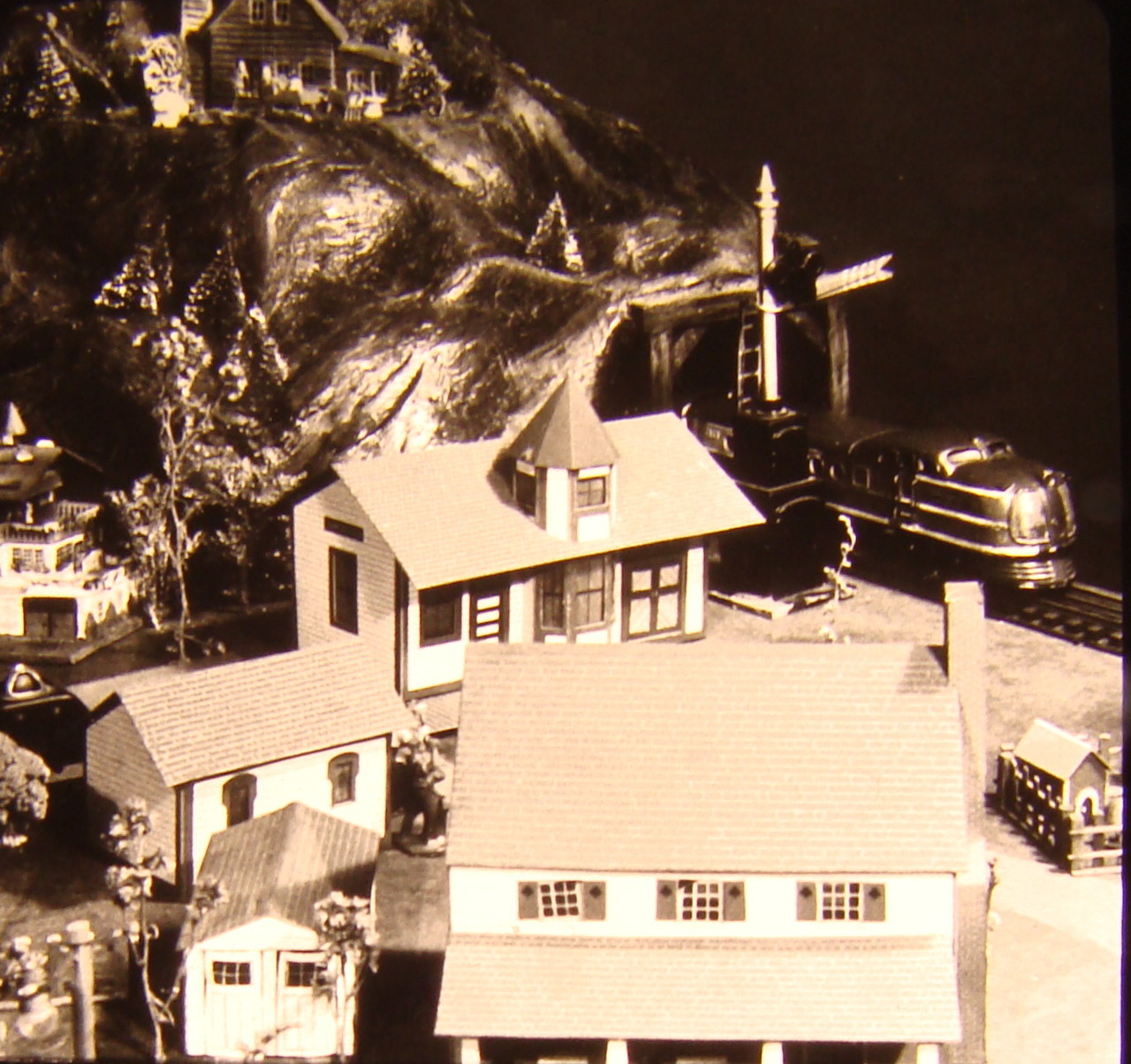 Black and white image on toy train layout with tunnel and town