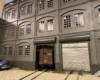A dark-grey three-story building serves as a partition.