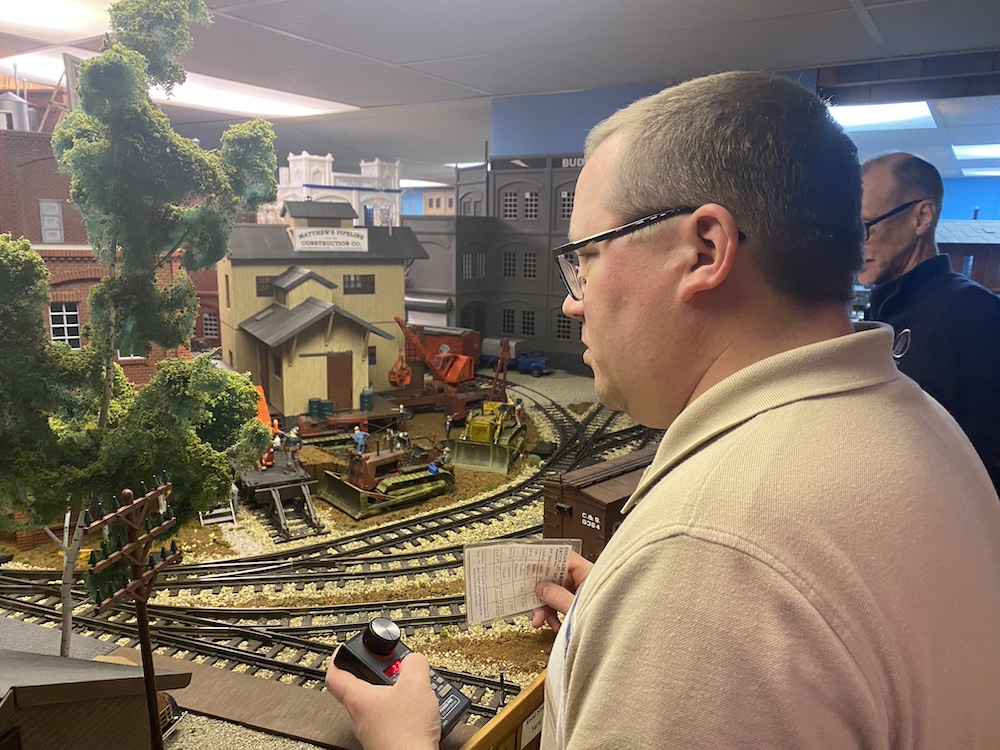 Behind-the-scenes of multiple operators switching cars on a layout.