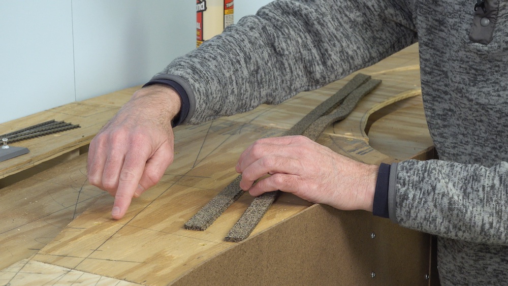 Finger pointing towards a marked-out line on a tabletop