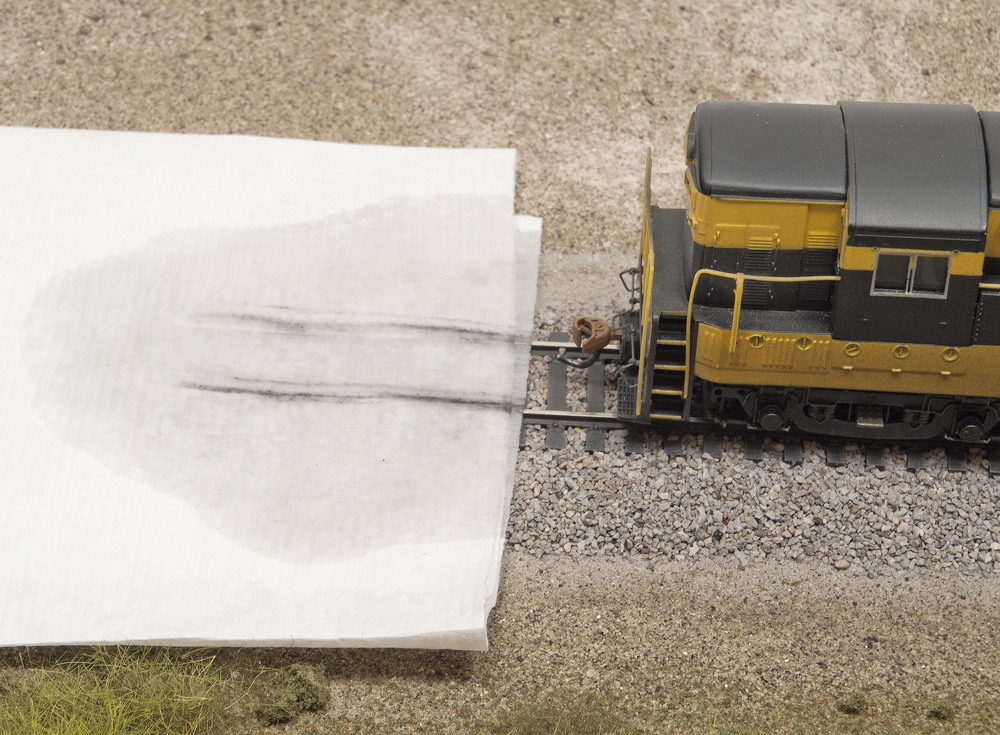 Color photo showing HO scale diesel by white paper towel with streaks of dirt on it.