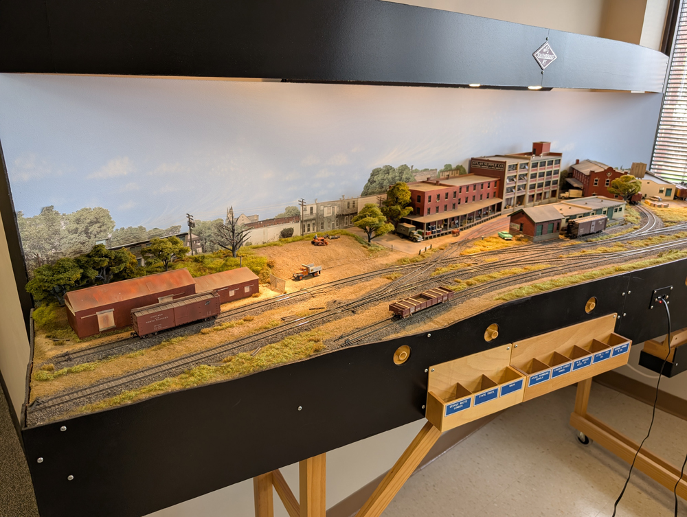 An HO scale locomotive and cars in different spots on a switching layout