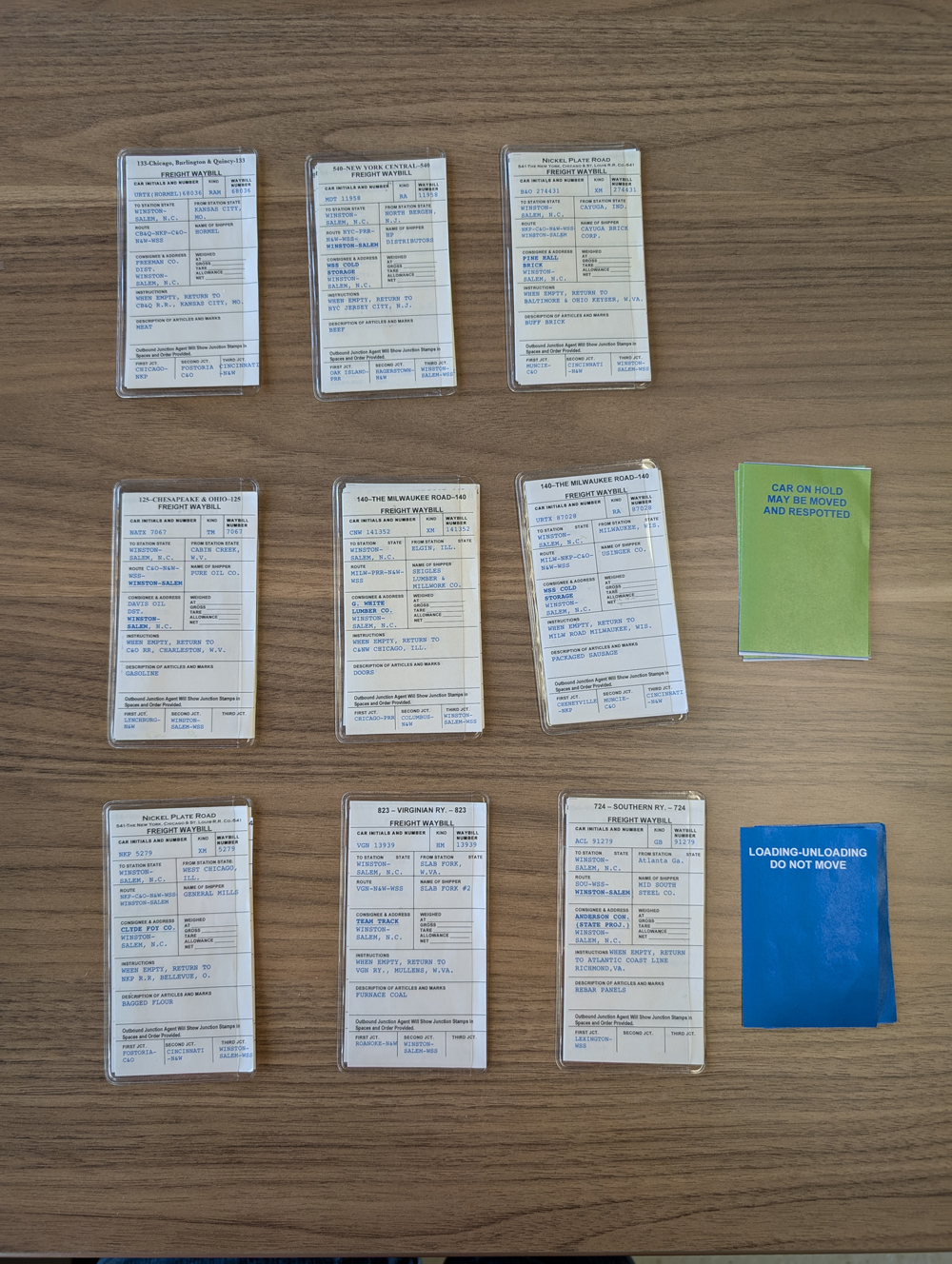 Nine model railroad car cards laid out in three columns and three rows with two additional colored cards.