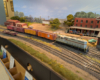 An HO scale GP7 with two reefers, a boxcar, and a caboose behind it