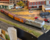 An HO scale GP7 with two reefers, a boxcar, and a caboose behind it