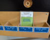 A model railroad car card with a green tag in front of it in a card pocket