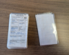 Two piles of model railroad car cards. One upside down.