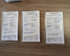 Three model railroad car cards with wood background
