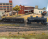 An HO scale GP7 with gondola and three-dome tank car behind