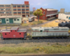 An HO scale GP7 shoving a red caboose