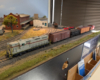 HO scale GP7 with boxcar, hopper, reefer, and caboose behind