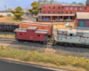 An HO scale GP7 shoving a caboose around a train