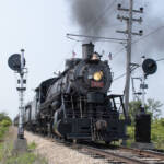 Steam locomotive passing between signals
