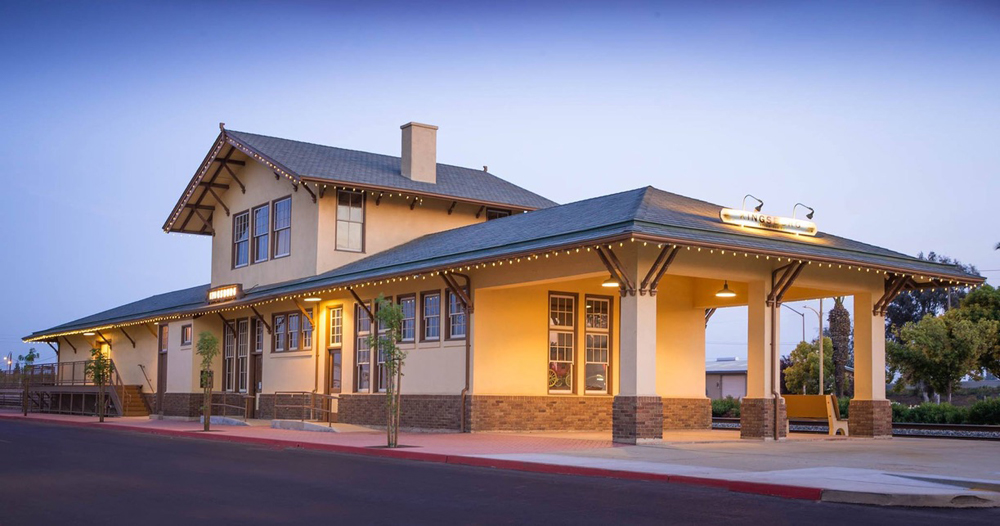 Two-story wooden railroad station at dusk