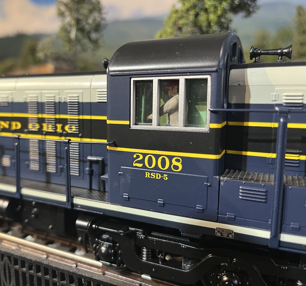 close up of cab of blue and gray model locomotive