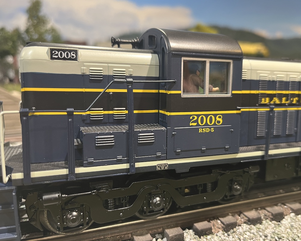 close up of cab of blue and gray model locomotive