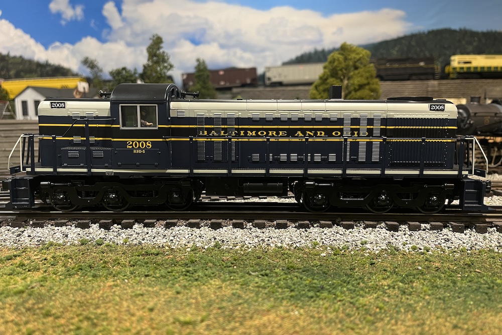 side view of blue and gray model locomotive on a layout