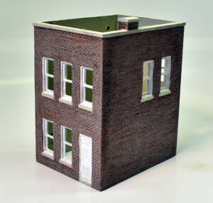 A small two-story brick building on a white background