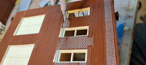 Thinned gray paint is flowed into the mortar lines of the brick