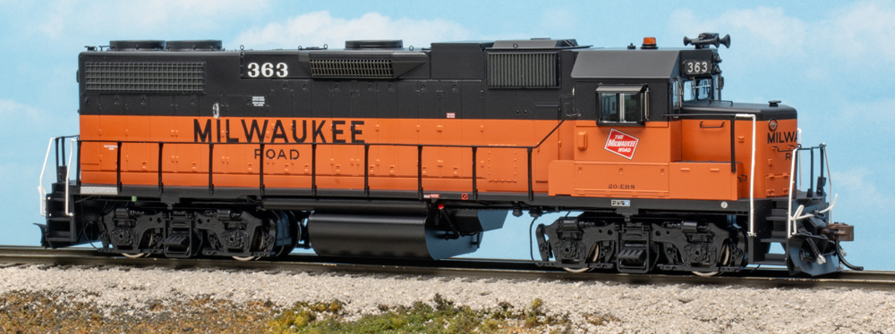 Color photo of HO scale diesel locomotive painted orange and black on scenicked base