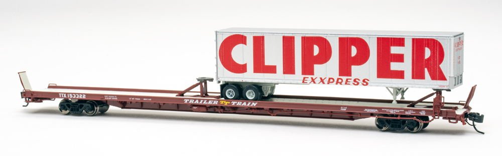 Color photo of N scale flatcar with trailer load on white background.
