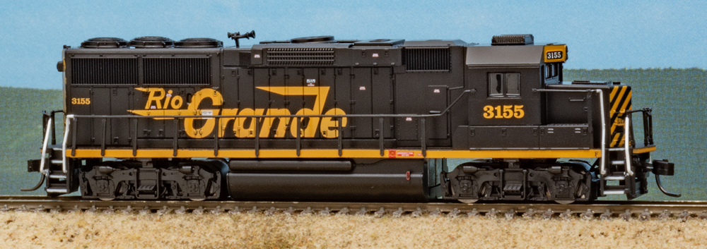 Color photo of N scale diesel locomotive painted orange and black on scenicked base.