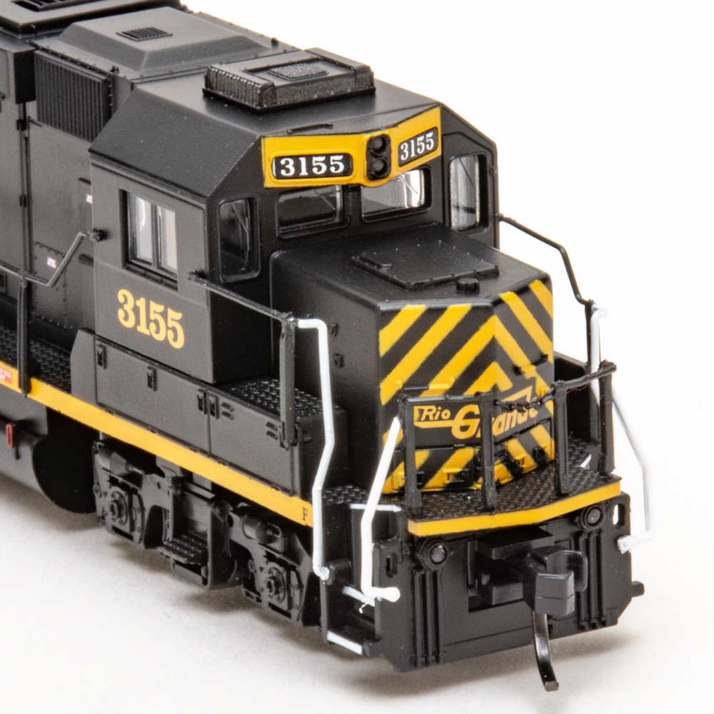 Color photo of N scale diesel locomotive painted orange and black on white background.